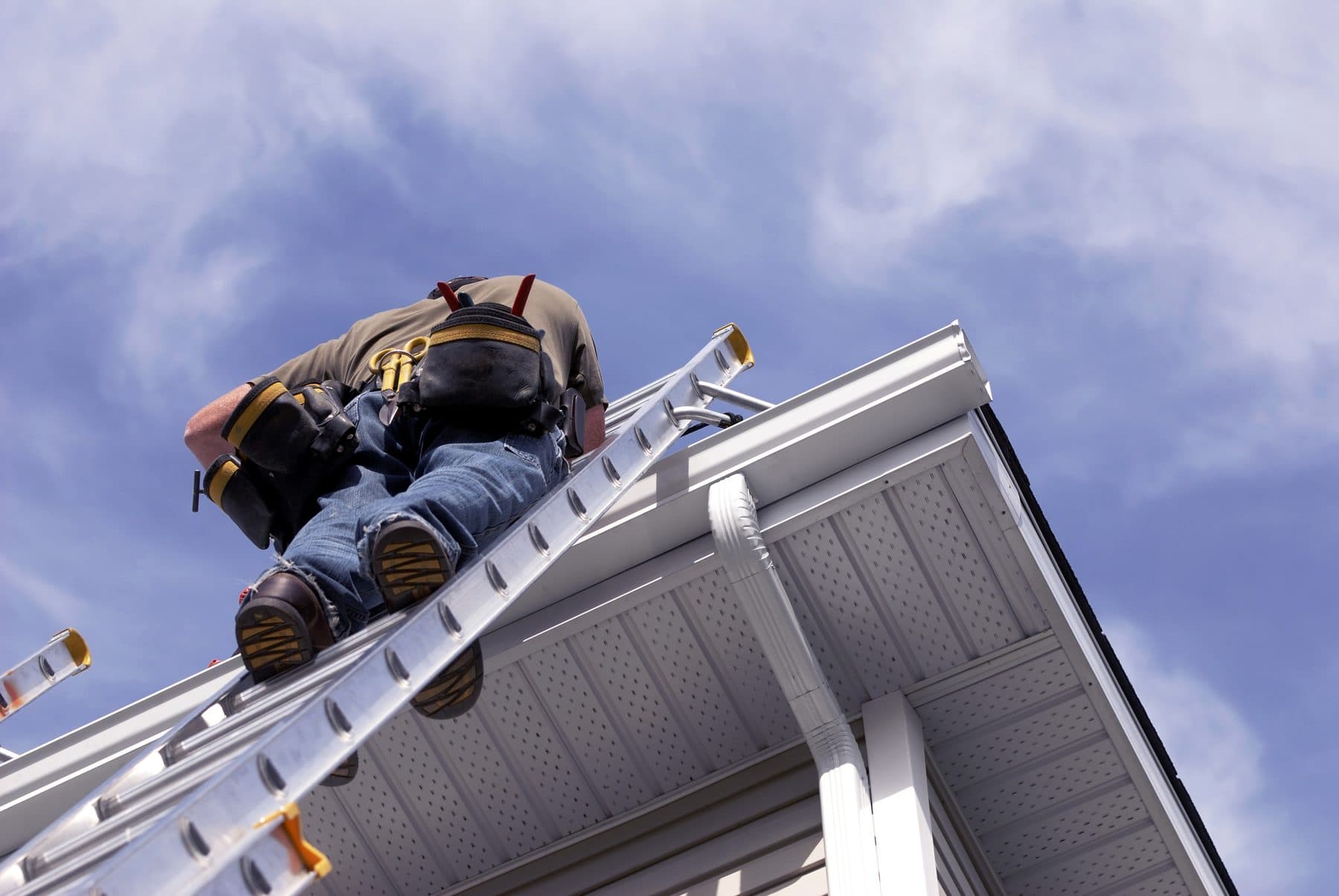 SA Roofing team member on a ladder working on a residential roof replacement