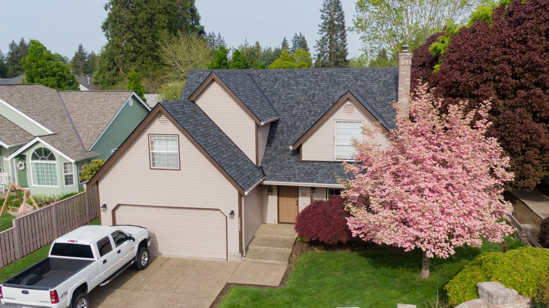 Finished residential roof by SA Roofing framed by spring foliage
